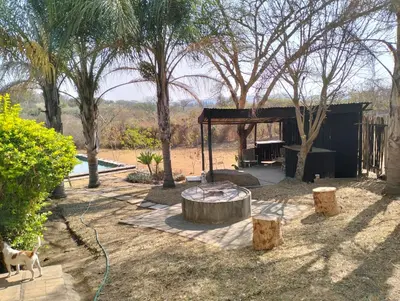 a garden with a table and some trees at Home Sweet Home Farmhouse in Nelspruit