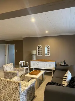 a living room with two couches and a table at Home Sweet Home Farmhouse in Nelspruit