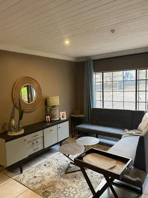 a living room with a couch and a mirror at Home Sweet Home Farmhouse in Nelspruit