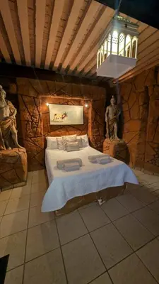 a bedroom with a large bed in a stone wall at La Mathil in Swartspruit