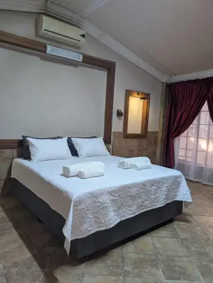 a bedroom with a large bed with towels on it at La Mathil in Swartspruit