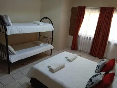 a room with two bunk beds and a window at La Mathil in Swartspruit