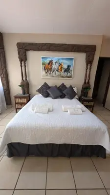 a bedroom with a large bed with two towels on it at La Mathil in Swartspruit