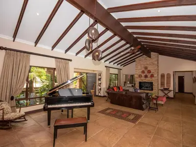 a living room with a piano and a couch at African Dream Villa in White River