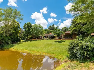 a house with a large yard with a pond at African Dream Villa in White River