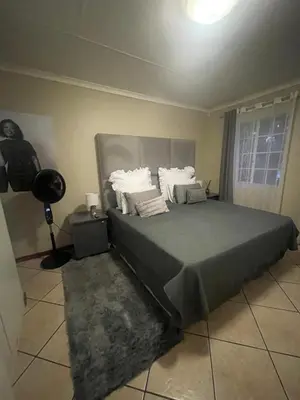 a bedroom with a large bed with white pillows at Tan 46 Park Acres in Nelspruit