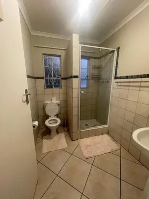 a bathroom with a toilet and a shower and a sink at Tan 46 Park Acres in Nelspruit