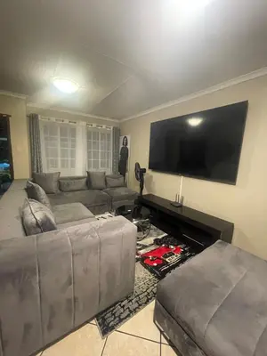 a living room with a couch and a flat screen tv at Tan 46 Park Acres in Nelspruit