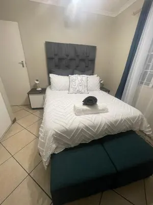 a bedroom with a large bed with a gray headboard at Tan 46 Park Acres in Nelspruit