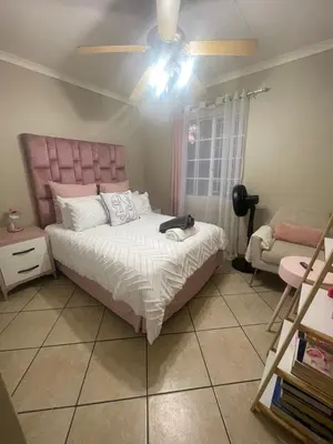 a bedroom with a bed and a ceiling fan at Tan 46 Park Acres in Nelspruit