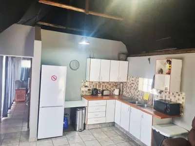 a kitchen with white cabinets and a white refrigerator at Lyttelton Self-Catering Accommodation in Centurion