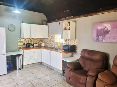 a kitchen with a couch and a chair in a room at Lyttelton Self-Catering Accommodation in Centurion