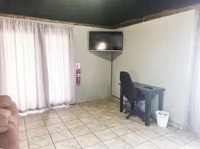 a room with a desk and a television on the wall at Lyttelton Self-Catering Accommodation in Centurion