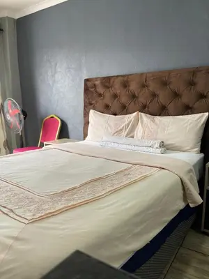 a bedroom with a large bed with a brown headboard at DA LIFE Guest House in Springs