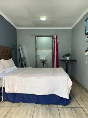 a bedroom with a large bed and a sink at DA LIFE Guest House in Springs