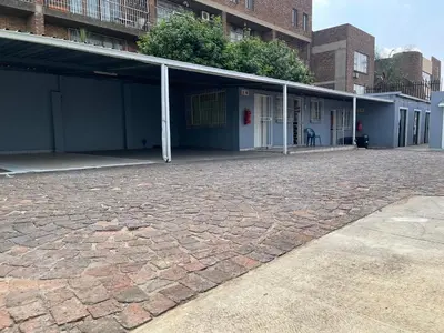an empty building with a brick driveway at DA LIFE Guest House in Springs