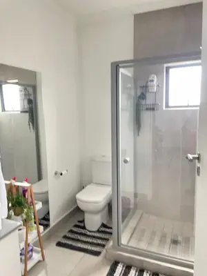 a bathroom with a toilet and a glass shower at Peaceful Nest in Midrand