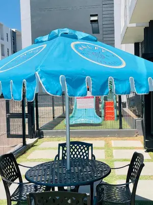 a table and chairs under a large blue umbrella at Peaceful Nest in Midrand