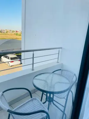 a glass table and two chairs on a balcony at Peaceful Nest in Midrand