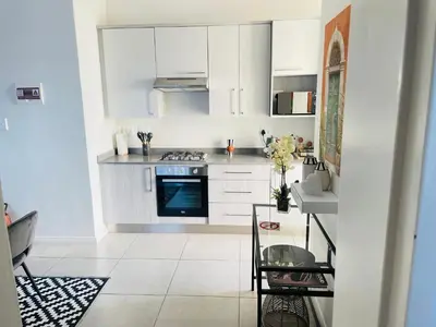 a kitchen with white cabinets and a blue oven at Peaceful Nest in Midrand
