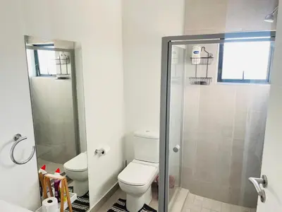 a bathroom with a toilet and a glass shower at Peaceful Nest in Midrand