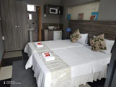 a bedroom with a large bed with white sheets and pillows at Home of peace and tranquility in Pretoria