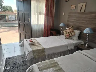 a hotel room with two beds and a window at Home of peace and tranquility in Pretoria