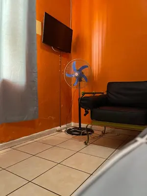 a room with a chair and a fan at Good Time Guest House in Springs