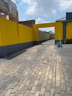 a yellow wall next to a parking lot at Good Time Guest House in Springs