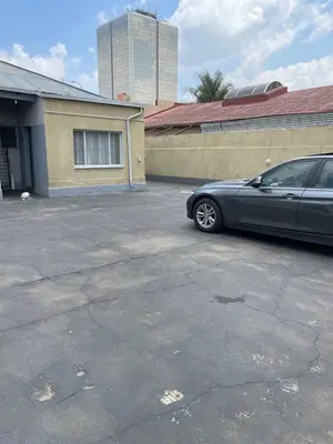 a car parked in a parking lot next to a building at Good Time Guest House in Springs