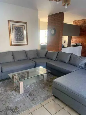 a living room with a blue couch and a coffee table at 177 San Ridge Village in Midrand