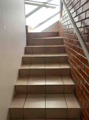 a staircase with a brick wall and a window at 177 San Ridge Village in Midrand
