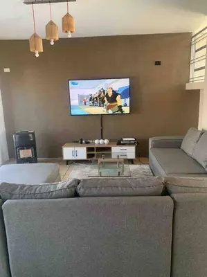 a living room with two couches and a flat screen tv at 177 San Ridge Village in Midrand