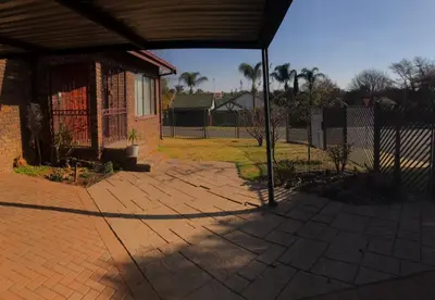 a brick patio with a fence and a house at Sandgrouse Guesthouse in Centurion