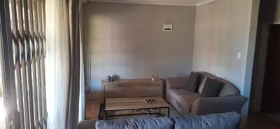 a living room with a couch and a table at Sandgrouse Guesthouse in Centurion