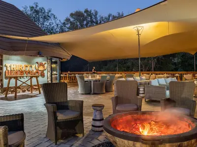 a patio with a fire pit and tables and chairs at Waterberg Game Park in Mokopane