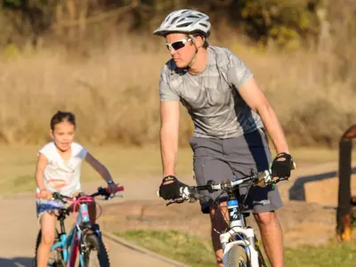 a man and a child riding bikes down a road at Waterberg Game Park in Mokopane