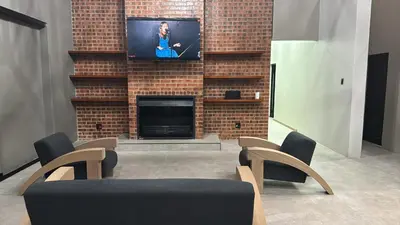 a living room with a fireplace with a flat screen tv at Golden Treasure - OFF GRID in Witbank