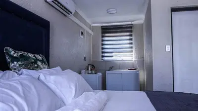 a bedroom with a white bed and a sink at Nsuku Guest House in Phalaborwa