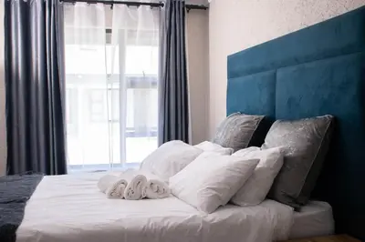 a bed with white pillows and a blue head board at Nsuku Guest House in Phalaborwa