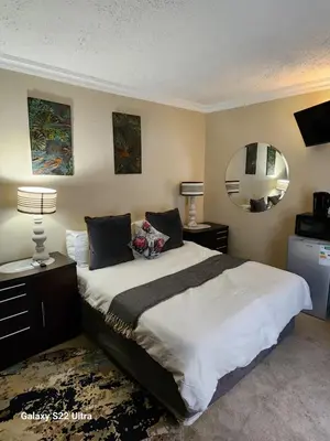 a bedroom with a large bed and a mirror at Lake View in Hartbeespoort