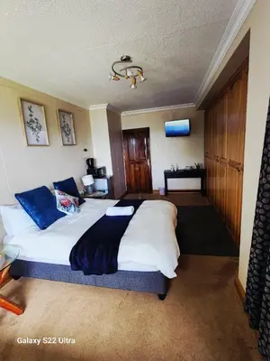 a bedroom with a large white bed with blue pillows at Lake View in Hartbeespoort