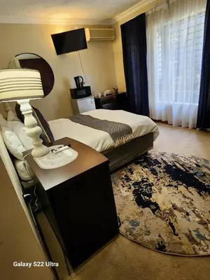 a bedroom with a bed and a table with a lamp at Lake View in Hartbeespoort