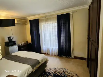 a hotel room with a bed and a window at Mountain Dreamers in Hartbeespoort