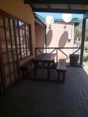 a picnic table and benches on a patio at 27 Pendleberry Grove, Chris Hani Drive, Bela-Bela in Bela-Bela