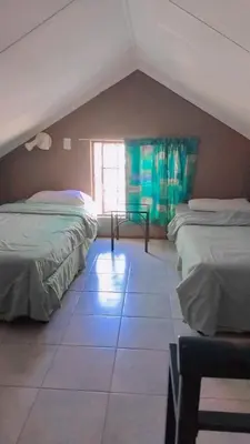 a attic room with two beds and a window at 27 Pendleberry Grove, Chris Hani Drive, Bela-Bela in Bela-Bela