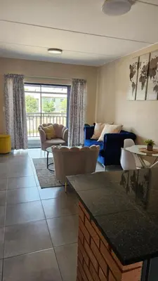 a living room with a couch and a table at Waterfall Ridge Professional Apartment in Midrand