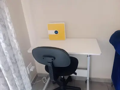 a desk with a chair and a yellow box on top at Waterfall Ridge Professional Apartment in Midrand