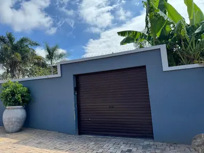 a blue garage door with a plant next to it at Spacious stay-in 1bedroom apartment in Kempton Park