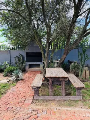 a wooden picnic table sitting on a brick path with a tree at Spacious stay-in 1bedroom apartment in Kempton Park